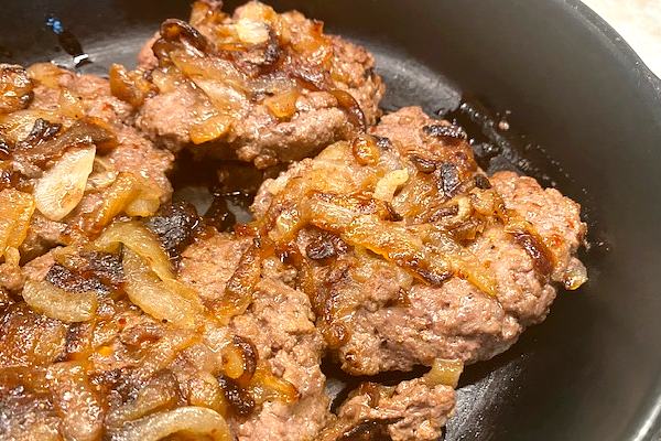 onion burgers in skillet
