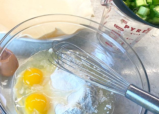 2 eggs and mixture in a glass bowl waiting to be mixed.