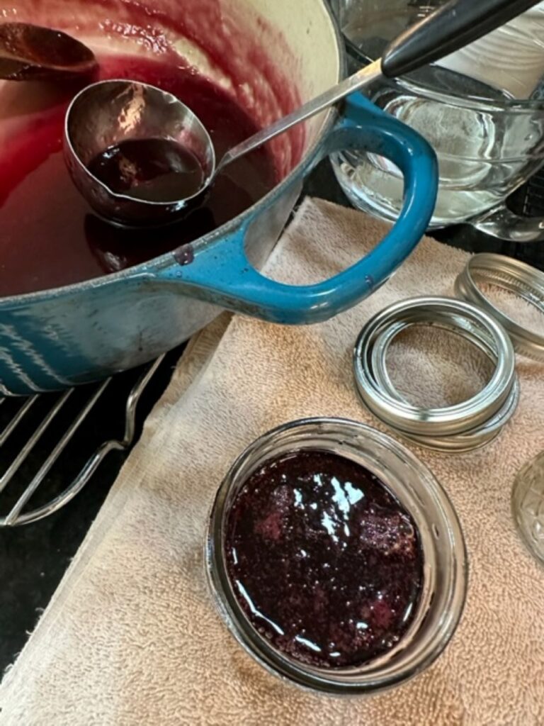 ladling grape jelly into jars